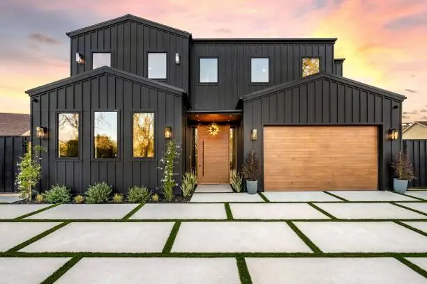 Modern black exterior with warm wood-toned accents by a house painter in Kansas City, MO.